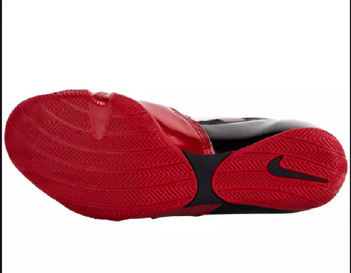 Low-profile red rubber outsole of Nike Hyperko 1 boxing shoe showing traction tread and black midfoot shank with Swoosh