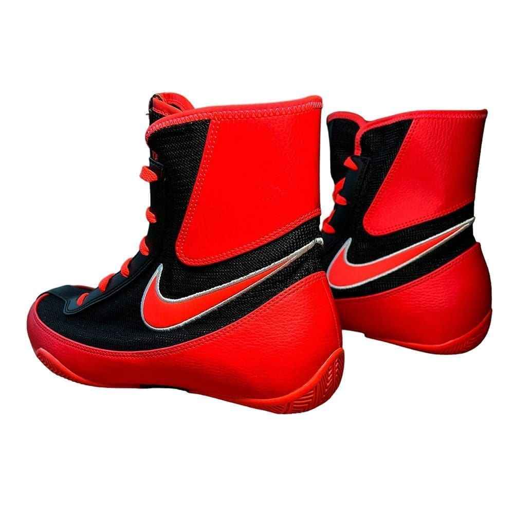 Bottom red rubber outsole of Nike Tawa shoe displaying split-sole tread, flex grooves, and black arch shank with Swoosh logo